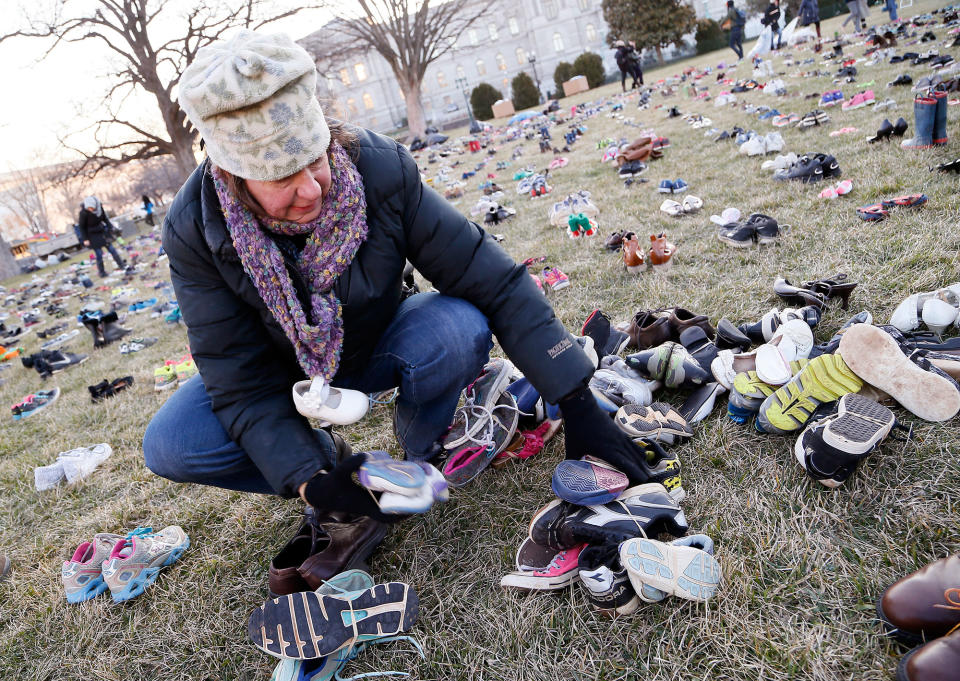 <p>A volunteer lays out 7,000 empty pairs of shoes for every child killed by guns in the US since Sandy Hook at the U.S. Capitol Building on Tuesday, March 13, 2018 in Washington. (Photo: Paul Morigi/AP Images for AVAAZ) </p>