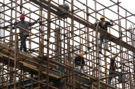 Men work on the scaffolding at a construction site of Hebei Zongheng Iron and Steel plant inside the Tangshan Fengnan Economic Development Zone, in Hebei province, China August 22, 2018. REUTERS/Joyce Zhou