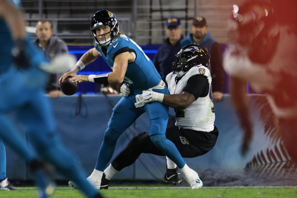 Jacksonville Jaguars quarterback Trevor Lawrence (16) is called for intentional grounding as Baltimore Ravens defensive tackle Justin Madubuike (92) wraps up during the third quarter of a regular season NFL football matchup Sunday, Dec. 17, 2023 at EverBank Stadium in Jacksonville, Fla. The Baltimore Ravens defeated the Jacksonville Jaguars 23-7. [Corey Perrine/Florida Times-Union]