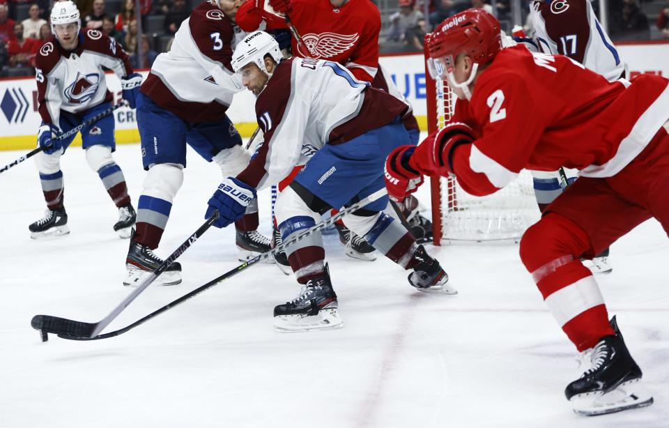 Colorado Avalanche center Andrew Cogliano (11) is pursued around the goal by Detroit Red Wings defenseman Olli Maatta (2) during the first period of an NHL hockey game Saturday, March 18, 2023, in Detroit. (AP Photo/Duane Burleson)