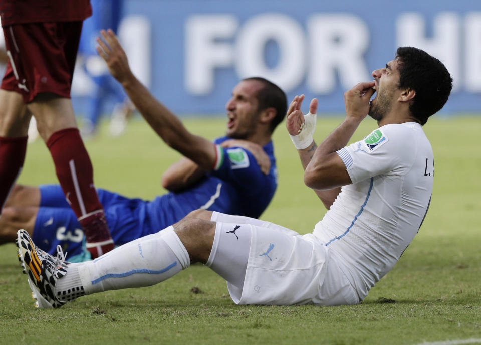 FILE - Uruguay's Luis Suarez holds his teeth after colliding with Italy's Giorgio Chiellini's shoulder during the group D World Cup soccer match between Italy and Uruguay at the Arena das Dunas in Natal, Brazil on June 24, 2014. (AP Photo/Ricardo Mazalan, File)