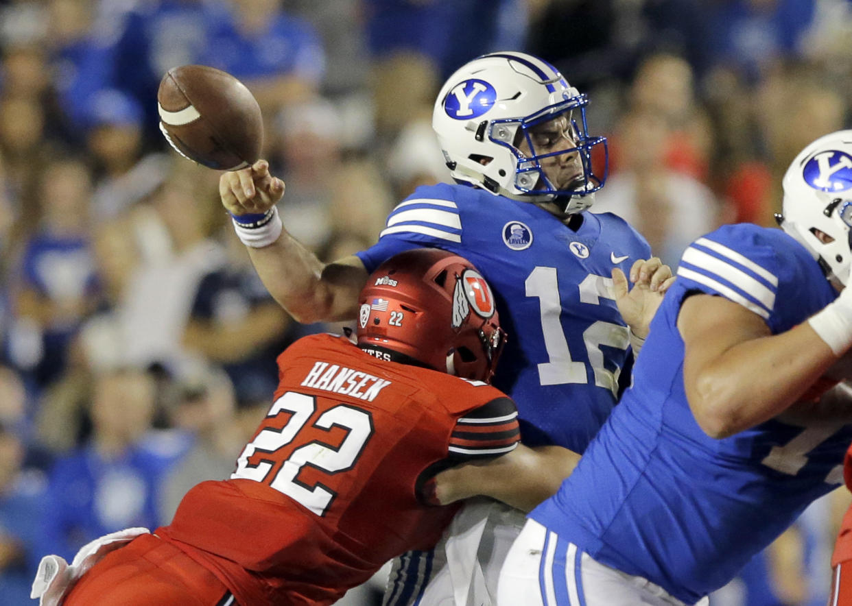 Utah defensive back Chase Hansen (22) hits BYU quarterback Tanner Mangum (12) in the first half during an NCAA college football game Saturday, Sept. 9, 2017, in Provo, Utah. (AP Photo/Rick Bowmer)