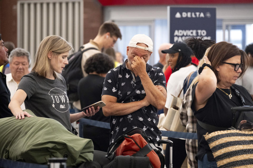 Tiffany McAllister and Andres Bernal try to rebook their flight to Iowa while at Hartsfield Jackson International Airport in Atlanta, Friday, July 19, 2024, as a major internet outage disrupts flights, banks, media outlets and companies across the world. (AP Photo/Ben Gray)