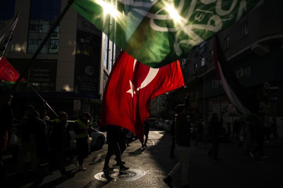 People wave Turkish and Hamas flags during a protest in support of Palestinians and calling for an immediate ceasefire in Gaza, in Istanbul, Turkey, Sunday, Jan. 14, 2024. (AP Photo/Emrah Gurel)