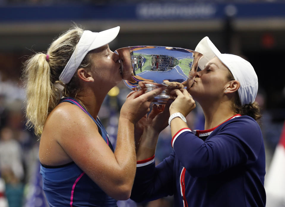 CoCo Vandeweghe, left, and Ashleigh Barty, of Australia, kiss the trophy after defeating Timea Babos, of Hungary, and Kristina Mladenovic, of France,in the women's double final of the U.S. Open tennis tournament, Sunday, Sept. 9, 2018, in New York. (AP Photo/Adam Hunger)