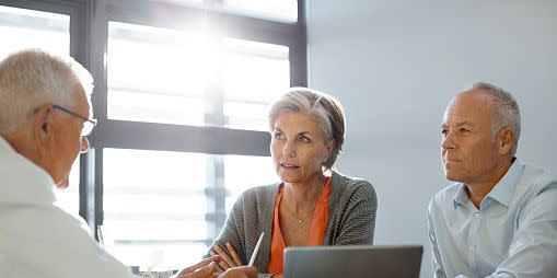 mature couple visiting doctor in hospital senior medical expertise is discussing with man and woman they are sitting at desk