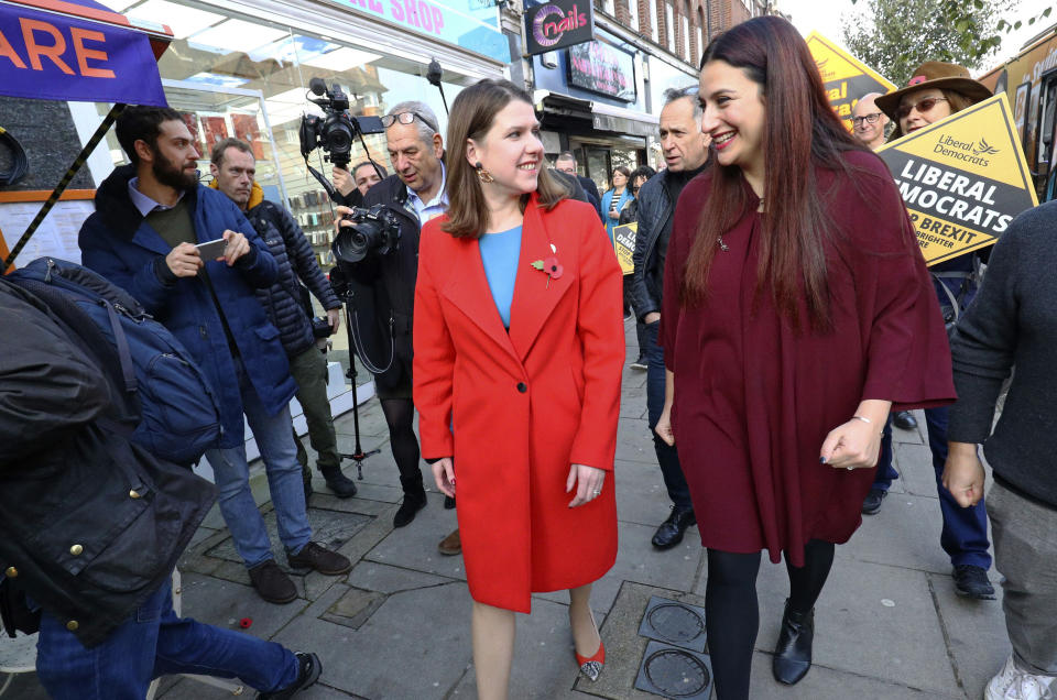 Britain's Liberal Democrat leader Jo Swinson, left, walks with the party's candidate for Finchley and Golders Green Luciana Berger as she arrives for a visit to a mental health enterprise in North London, Wednesday Nov. 6, 2019. Britain's three major national political parties wooed weary voters on Tuesday, all promising an end to Brexit wrangling if they win next month's national election — but offering starkly different visions of how to achieve that. (Aaron Chown/PA via AP)