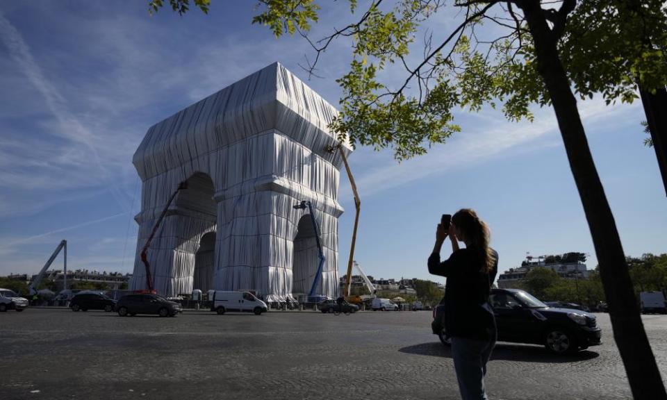 An onlooker takes a picture as workers put the final touches to the Arc’s wrapping.