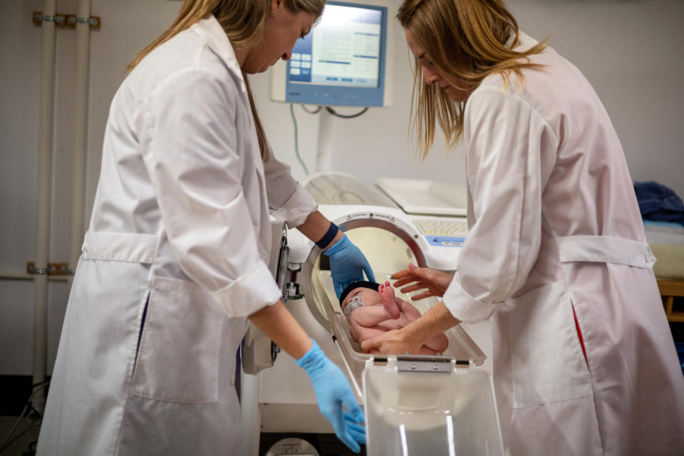 Redman, right, and Ph.D. Emily Flanagan, place baby Jameson Hardee in the Pea Pod. (Kathleen Flynn for NBC News)