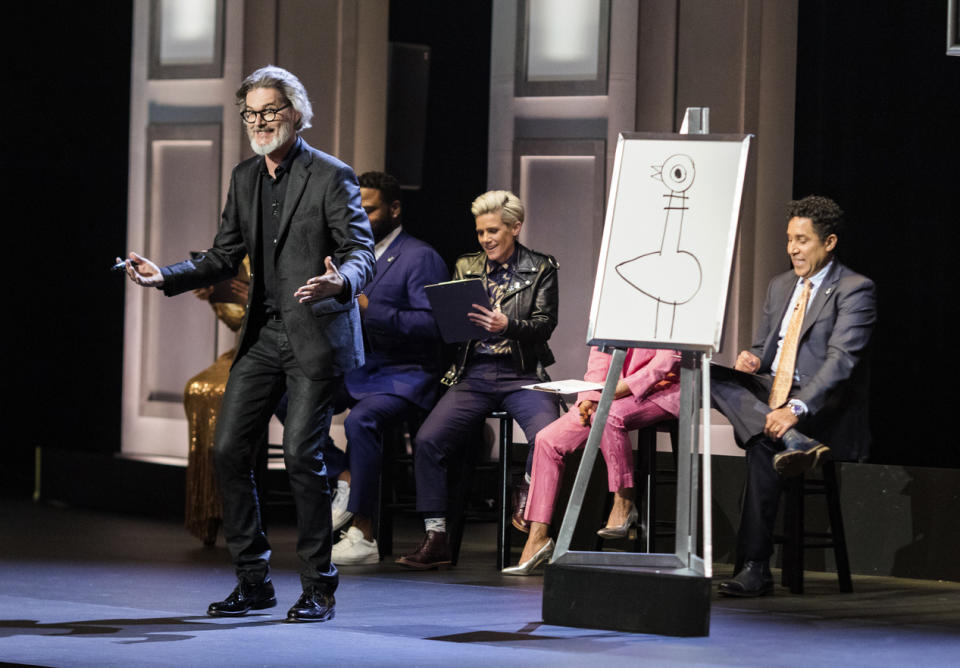 This image released by HBO Max shows author and illustrator Mo Willems, standing, in “Don’t Let the Pigeon Do Storytime!” The special was filmed last year at the Kennedy Center and features comedy inspired by Willems’ books for children. (HBO Max via AP)