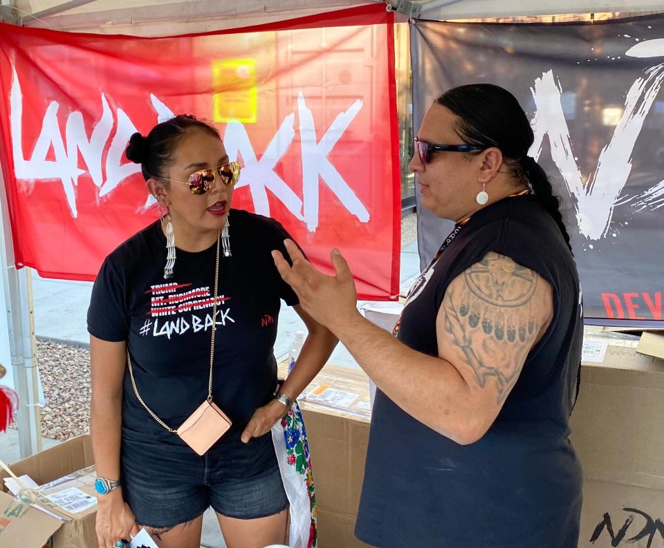 Janene Yazzie, Southwest regional director of NDN Collective, talks with Nick Tilson, president of the collective, at their NDN Collective booth during Indigenous Peoples Day Phoenix Fest.