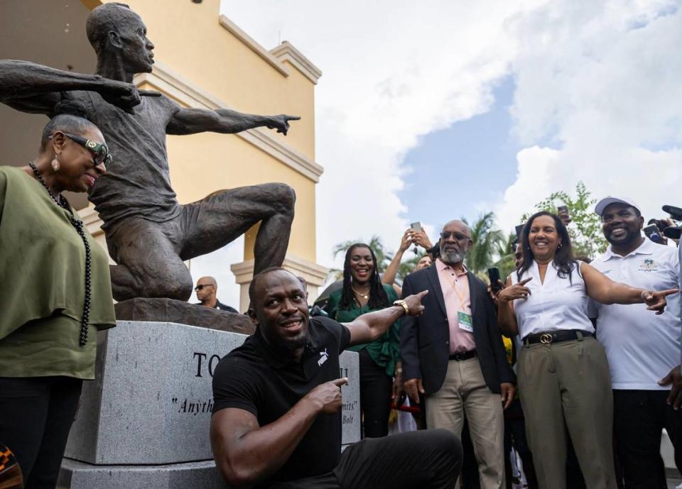 Olympic gold medalist Usain Bolt recreates his famous pose in front of a bronze sculpture at the Ansin Sports Complex in Miramar on Saturday.