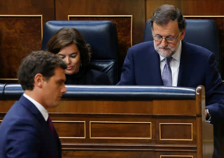 Ciudadanos (Citizens) party leader Albert Rivera (L) walks by Spain's acting Prime Minister and People's Party (PP) leader Mariano Rajoy (R) and acting Deputy Prime Minister Soraya Saenz de Santamaria during an investiture debate at parliament in Madrid, Spain August 31, 2016. REUTERS/Andrea Comas