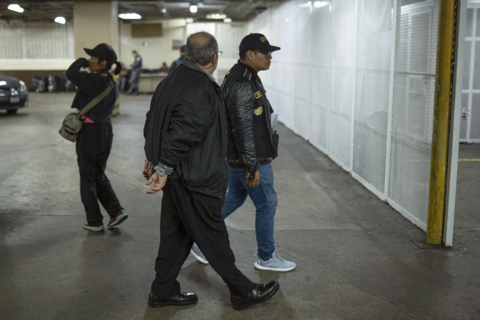 University professor Eduardo Velásquez is brought to court in handcuffs in Guatemala City, Thursday, Nov. 16, 2023. Guatemalan prosecutors said Thursday they will seek to strip President-elect Bernardo Arévalo and several members of his party of their immunity for allegedly making social media posts that encouraged students to take over a public university in 2022. (AP Photo/Santiago Billy)