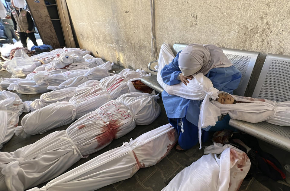 A Palestinian woman reacts over the body of a child as she sits by bodies of Palestinians killed by Israeli airstrikes on Jabaliya refugee camp, at the Indonesian hospital, northern Gaza Strip, Saturday, Nov. 18, 2023. (AP Photo/Ahmed Alarini)