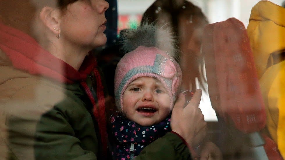 A Ukrainian refugees child reacts as he boards a bus after arriving at Hendaye train station, southwestern France