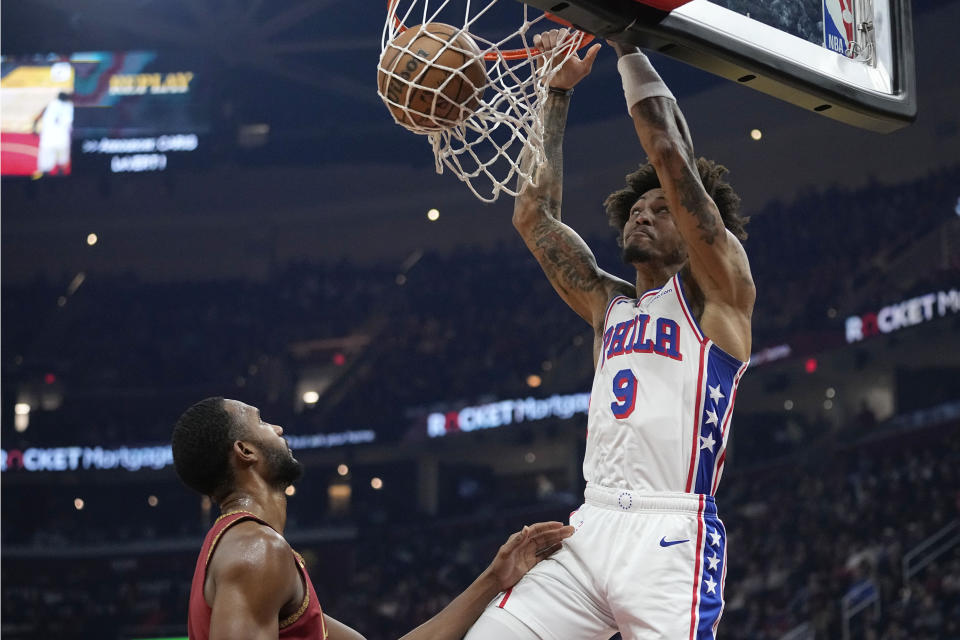 Philadelphia 76ers guard Kelly Oubre Jr. (9) dunks over Cleveland Cavaliers forward Evan Mobley, left, in the first half of an NBA basketball game, Monday, Feb. 12, 2024, in Cleveland. (AP Photo/Sue Ogrocki)