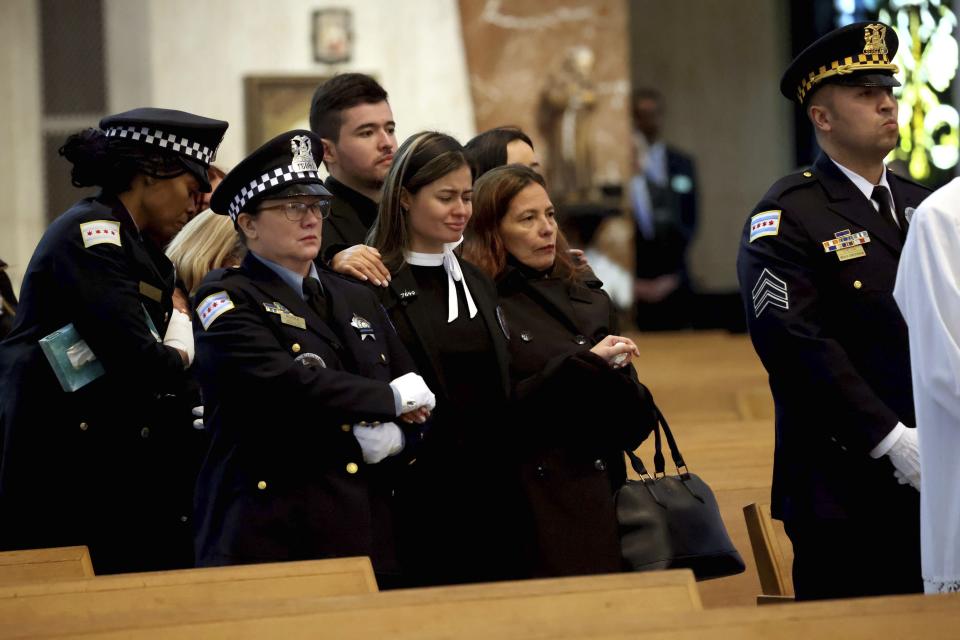 Milena Estepa de Vásquez, the widow of Chicago police Officer Andres Vasquez-Lasso, is escorted into the funeral Mass at St. Rita of Cascia Shrine Chapel on Thursday, March 9, 2023 in Chicago. Vasquez-Lasso was shot and killed as he responded to reports of a man chasing a woman with a gun in Gage Park. (Stacey Wescott/Chicago Tribune via AP, Pool)