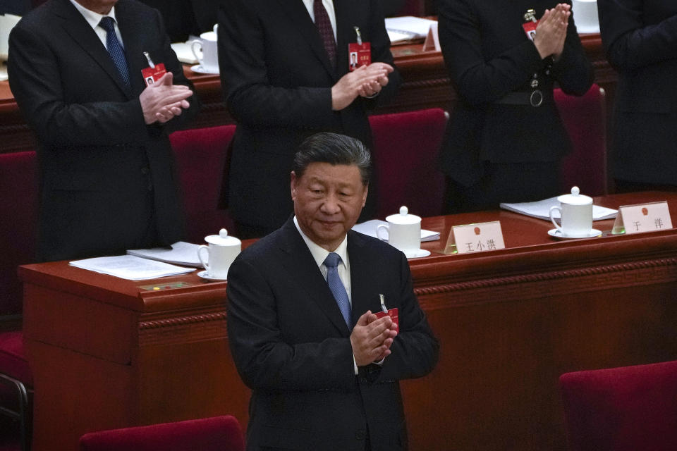 Chinese President Xi Jinping and delegates applaud as they arrive for the second plenary session of the National People's Congress (NPC) at the Great Hall of the People in Beijing, Friday, March 8, 2024. (AP Photo/Andy Wong)