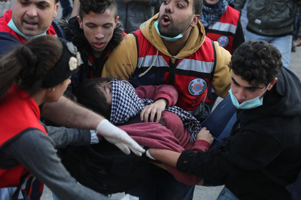 <p>Palestinian health team members carry a wounded protester during a protest against the US President Donald Trumps recognition of Jerusalem as Israels capital, at Beit El checkpoint in Ramallah, West Bank on Dec. 7, 2017. (Photo: Issam Rimawi/Anadolu Agency/Getty Images) </p>