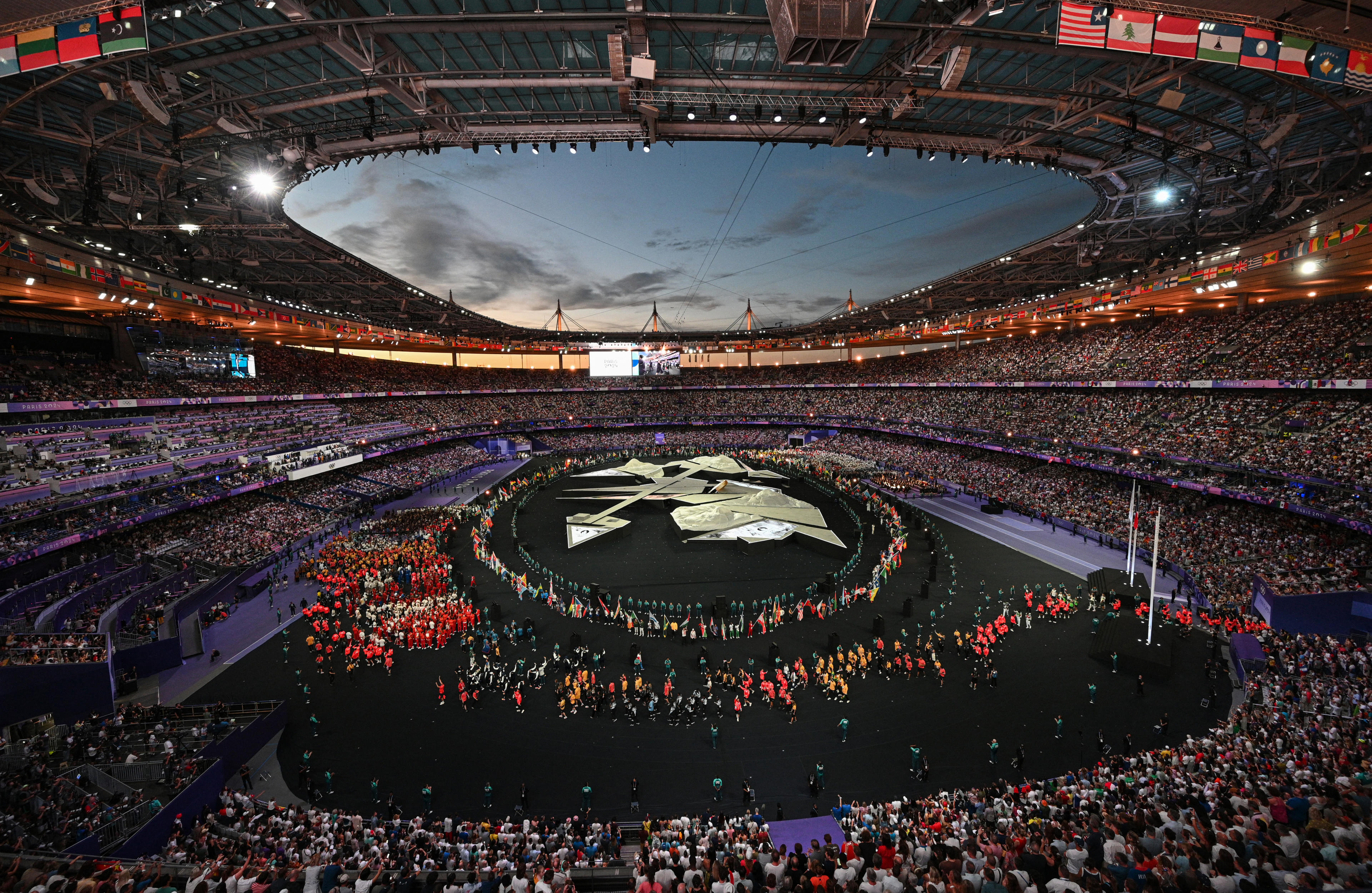 TOPSHOT - Athletes take part in the athletes parade during the closing ceremony of the Paris 2024 Olympic Games at the Stade de France in Saint-Denis on the outskirts of Paris on August 11, 2024. (Photo by Bertrand GUAY / AFP) (Photo by BERTRAND GUAY/AFP via Getty Images)