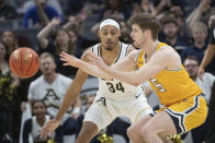 Kent State's Mike Bekelja passes in front of Akron's Nate Johnson (34) during the first half of an NCAA college basketball game in the championship of the Mid-American Conference tournament, Saturday, March 16, 2024, in Cleveland. (AP Photo/Phil Long)
