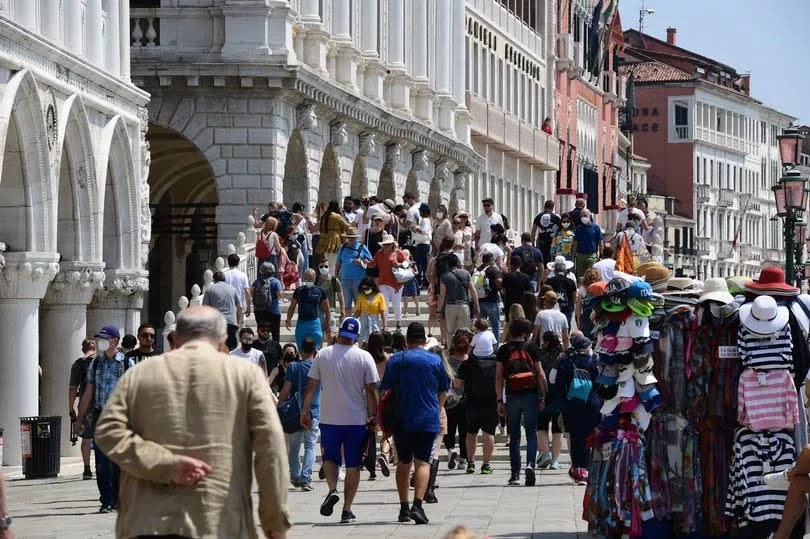 Tourists stroll across the Ponte della Paglia bridge in Venice on June 05, 2021