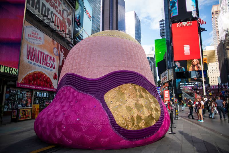 People visit the Fountain for Survivors, an immersive, 18-foot tall fountain covered in a mosaic of over 365,000 acrylic nails in Times Square in the Manhattan borough of New York, New York