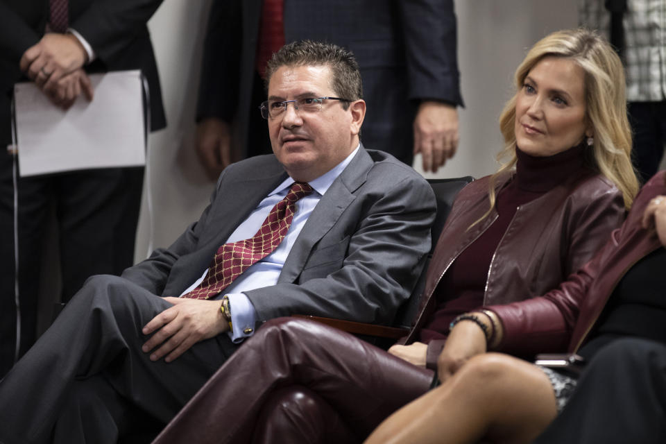 FILE - Washington Redskins owner Dan Snyder, left, and his wife Tanya Snyder, listen to head coach Ron Rivera during a news conference at the team's NFL football training facility in Ashburn, Va., in this Thursday, Jan. 2, 2020, file photo. The NFL has fined the Washington Football Team $10 million and owner Dan Snyder is stepping away from day-to-day operations after an independent investigation into the organization’s workplace misconduct. The team was not stripped of any draft picks as part of the league’s discipline that was announced Thursday, July 1, 2021. Snyder says his wife Tanya will be in charge for the next “several months.” (AP Photo/Alex Brandon, File)