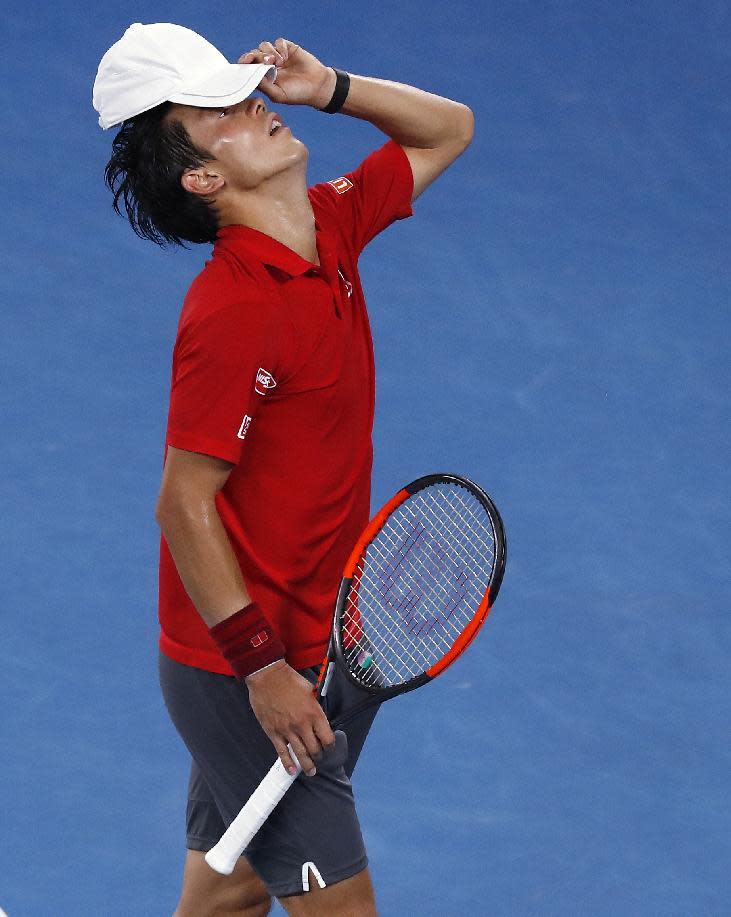 Japan's Kei Nishikori adjusts his hat while playing Switzerland's Roger Federer in their fourth round match at the Australian Open tennis championships in Melbourne, Australia, Sunday, Jan. 22, 2017. (AP Photo/Kin Cheung)