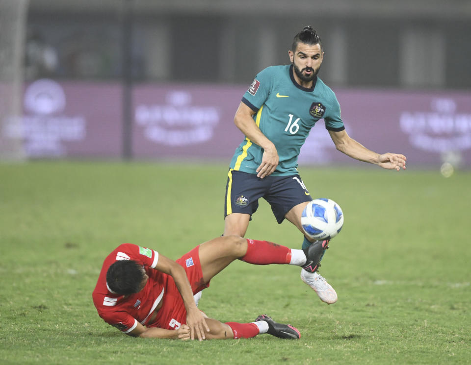 Australia's Aziz Behich, top, and Nepal's Sunil Bal fight for the ball during the World Cup 2022 Group B qualifying soccer match between Nepal and Australia in Kuwait City, Kuwait, Friday. June 11, 2021. (AP Photo/Jaber Abdulkhaleg)
