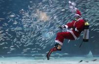 SEOUL, SOUTH KOREA - DECEMBER 08: A South Korean diver clad in Santa Claus costume swims with sardines at The Coex Aquarium on December 8, 2012 in Seoul, South Korea. Even though the official religion of South Korea is Buddhism, about 30 percent of it is Christian and Christmas is one of the biggest holidays to be celebrated in South Korea. (Photo by Chung Sung-Jun/Getty Images)