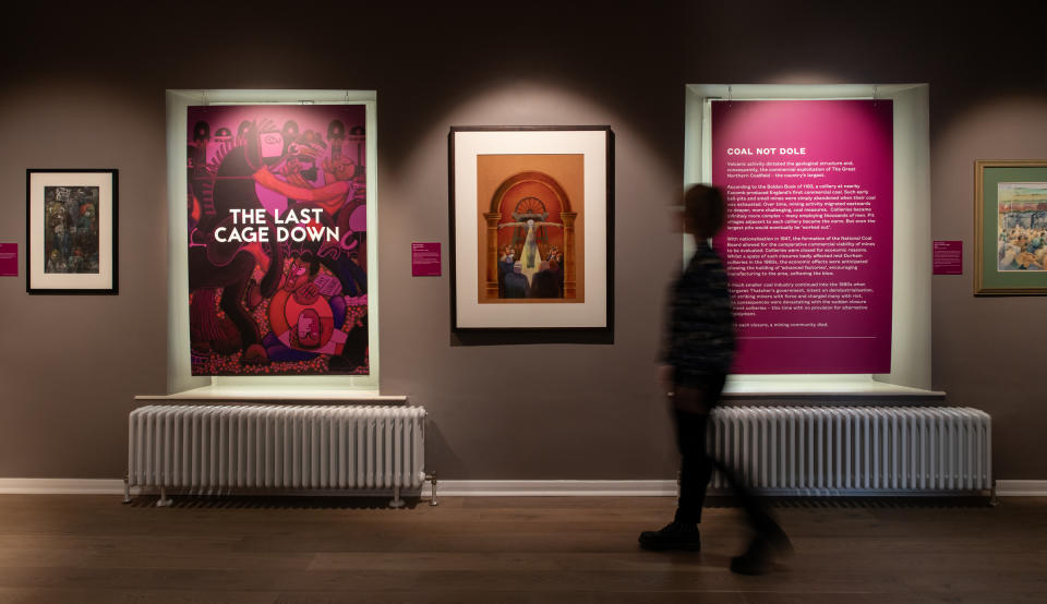 People walk through the Last Cage Down exhibition at the Mining Art Gallery