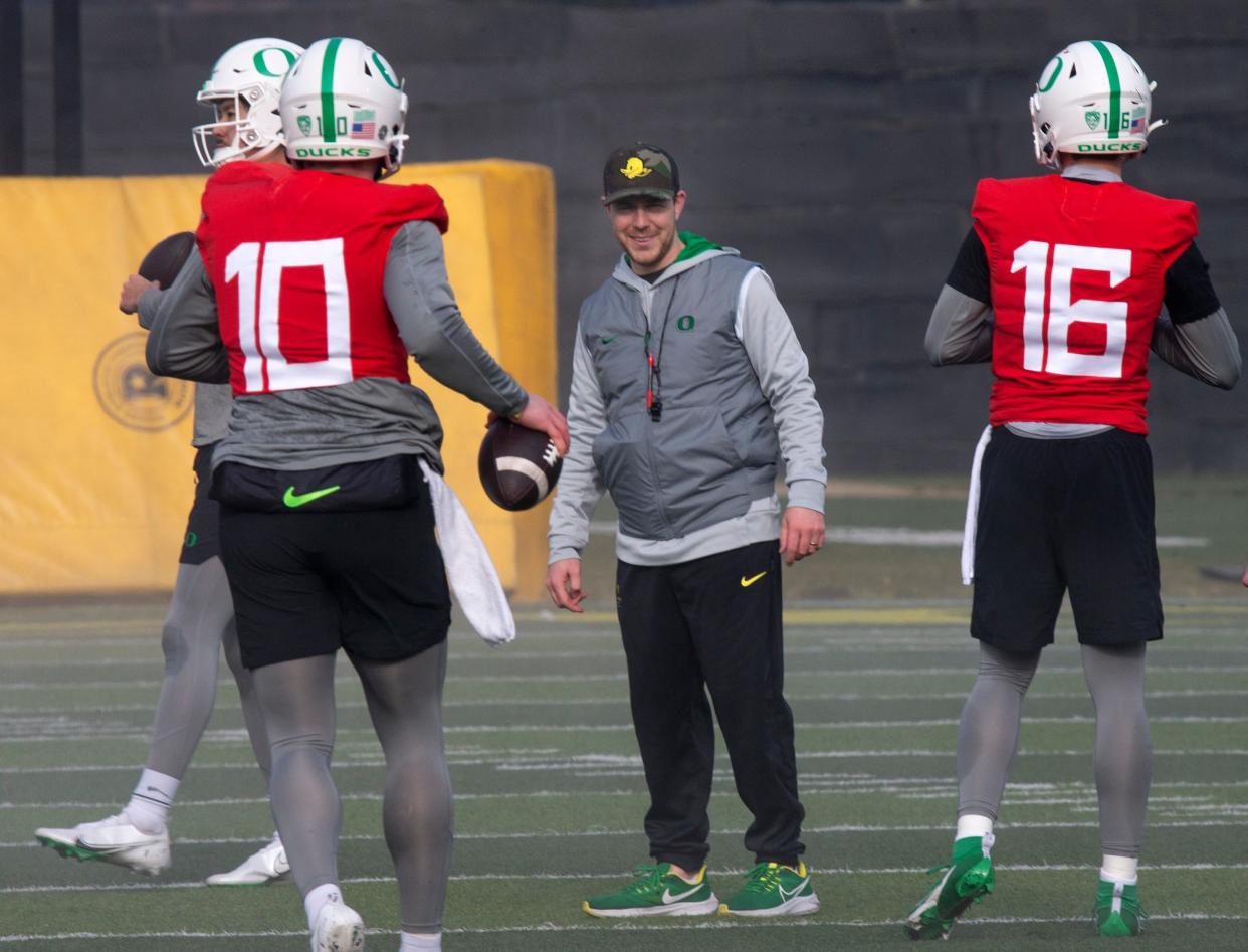 New Oregon offensive coordinator and quarterbacks coach Will Stein, center, leads a drill on the first practice of spring for Oregon football as the Ducks prepare for the 2023 season.