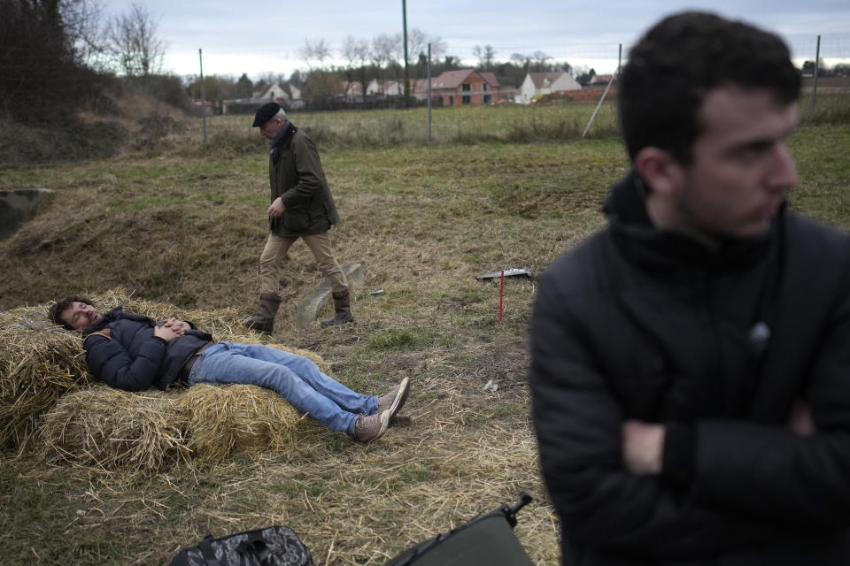 A farmer takes a nap as farmers block a highway Tuesday, Jan. 30, 2024 in Jossigny, east of Paris. With protesting farmers camped out at barricades around Paris, France's government hoped to calm their anger with more concessions Tuesday to their complaints that growing and rearing food has become too difficult and not sufficiently lucrative. (AP Photo/Christophe Ena)