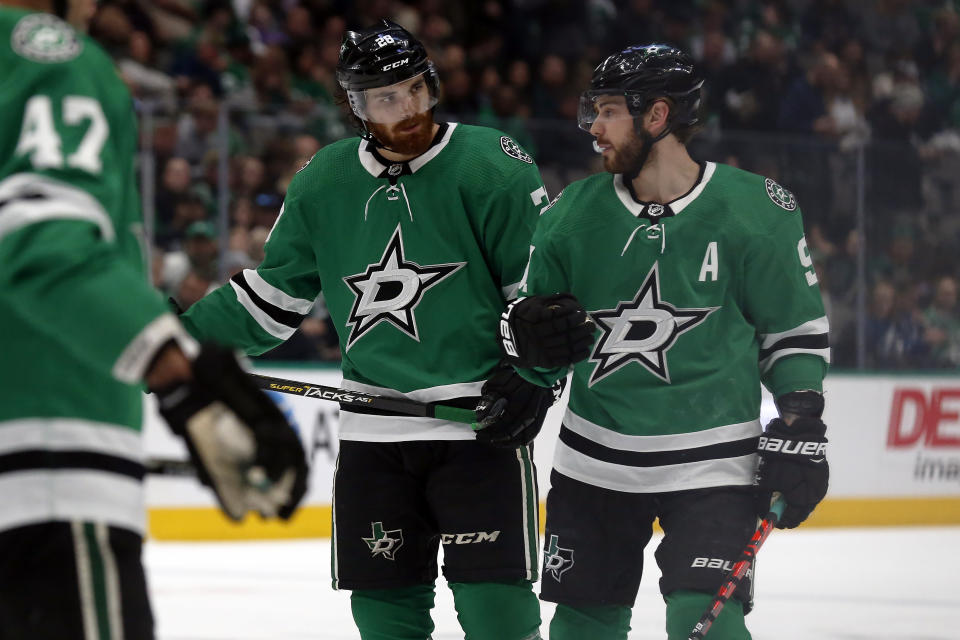 Dallas Stars defenseman Stephen Johns, left, talks with Dallas Stars center Tyler Seguin, right, during a break in the action in the second period of an NHL hockey game against the Tampa Bay Lightning in Dallas, Monday, Jan. 27, 2020. (AP Photo/Ray Carlin)