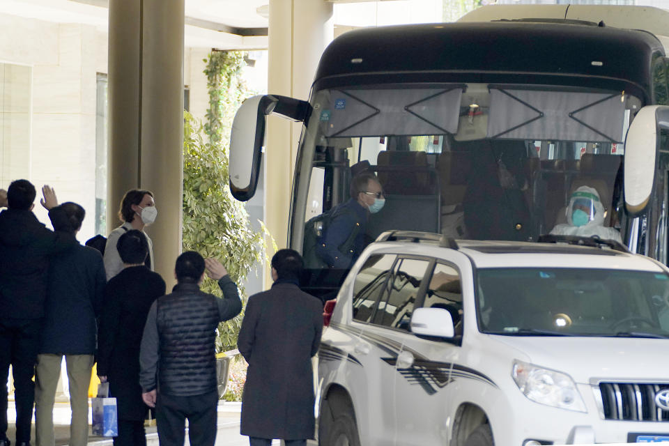 Workers wave to the team of experts from the World Health Organization who ended their quarantine and prepare to leave the quarantine hotel by bus in Wuhan in central China's Hubei province on Thursday, Jan. 28, 2021. (AP Photo/Ng Han Guan)