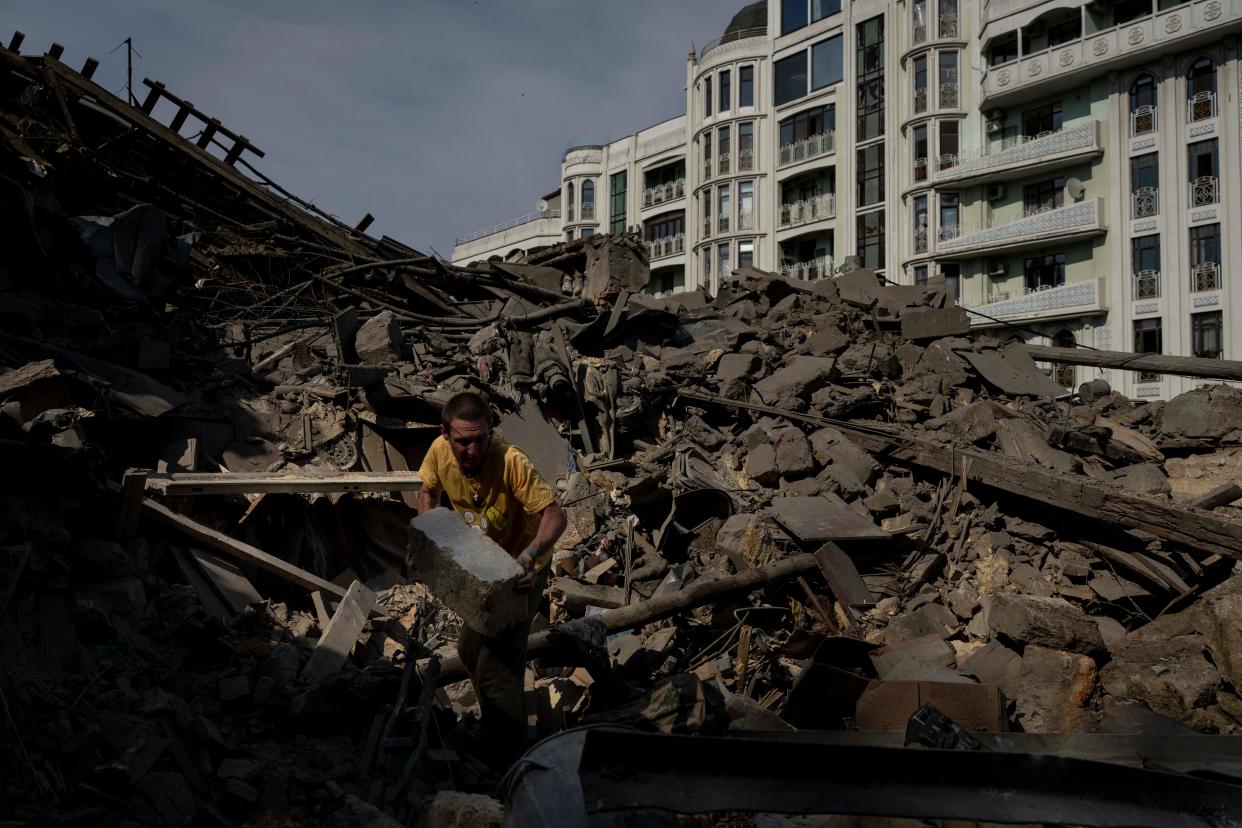 A man works on the rubble of an apartment building destroyed in Russian missile attacks in Odesa on July 23, 2023.