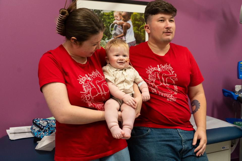 Abigail Robinson and Christian Rodriguez hold Elias after his checkup at Dell Children's. The family from Fort Cavazos was referred to Dell Children's after a blood flow problem was detected when Robinson was 23 weeks pregnant.