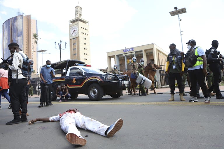 El cuerpo de un hombre que recibió un disparo en la cabeza yace junto al parlamento de Kenia durante una protesta por la propuesta de aumentos de impuestos en un proyecto de ley de finanzas en el centro de Nairobi