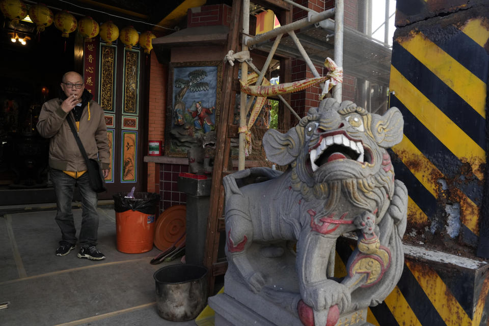 A man smokes outside temple in Taipei, Taiwan, Thursday, Jan. 11, 2024. Beijing's threats to use force to claim self-governed Taiwan aren't just about missiles and warships. Hard economic realities will be at play as voters head to the polls on Saturday, though the relationship is complicated. (AP Photo/Ng Han Guan)
