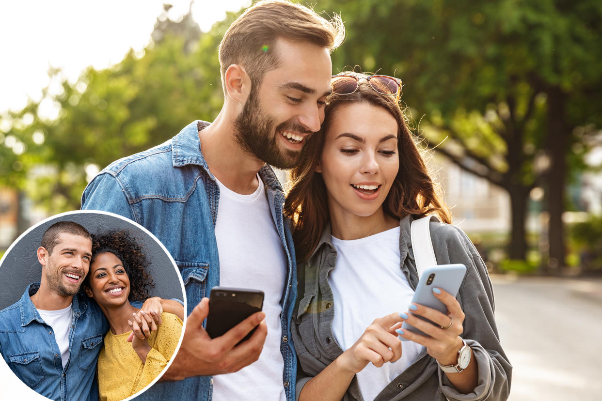 Young couple in love walking on a city street while using their mobile phones