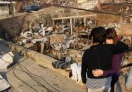 Residents survey the damage after a forest fire burned homes in Valparaiso city, northwest of Santiago, April 13, 2014. At least 11 people were killed and 500 houses destroyed over the weekend by a fire that ripped through parts of Chilean port city Valparaiso, as authorities evacuated thousands and used aircraft to battle the blaze. REUTERS/Eliseo Fernandez (CHILE - Tags: ENVIRONMENT DISASTER)