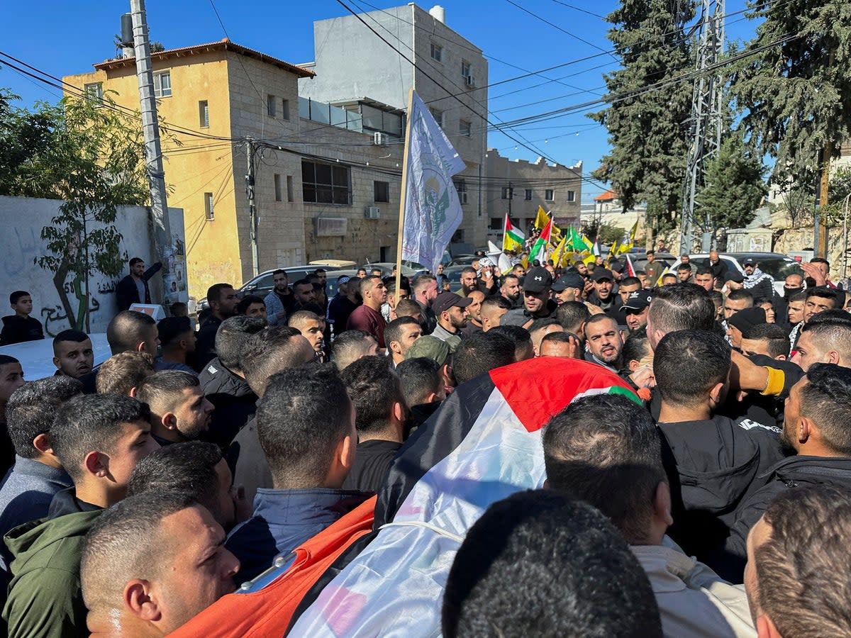 Mourners on December 3 carried the body of 38-year-old Palestinian Ahmad Assi after he was killed in an Israeli settler raid near Salfit in the occupied West Bank (REUTERS)