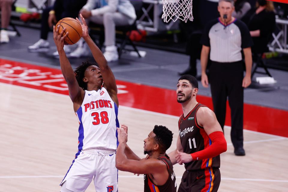 Detroit Pistons guard Saben Lee (38) goes to the basket on Portland Trail Blazers guard CJ McCollum (3) and center Enes Kanter (11) in the first half at Little Caesars Arena on March 31, 2021.