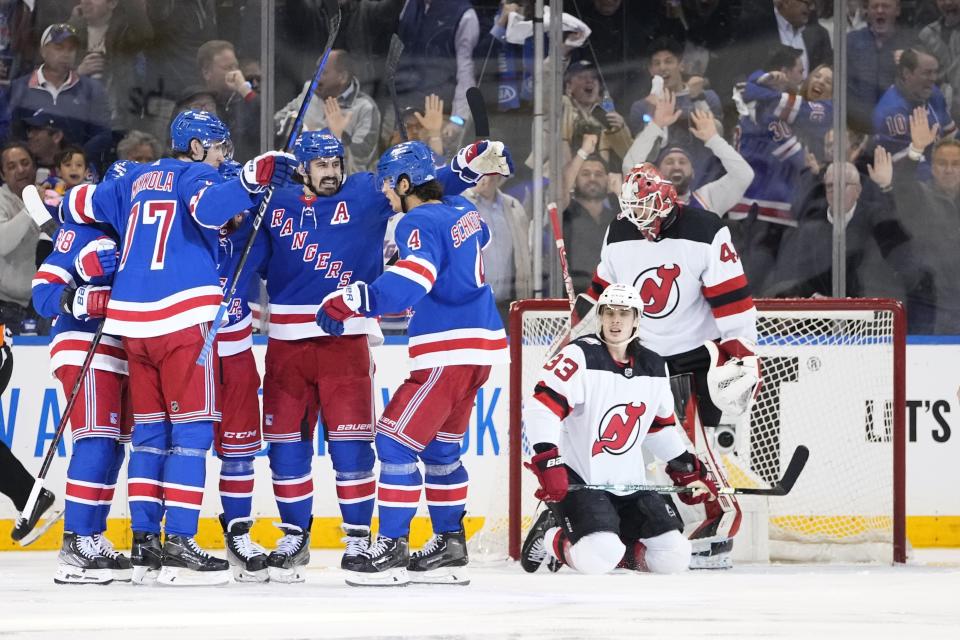 The New York Rangers celebrate a goal by Vincent Trocheck as New Jersey Devils goaltender Akira Schmid (40) and Ryan Graves (33) react during the third period of Game 4 of an NHL hockey Stanley Cup first-round playoff series Monday, April 24, 2023, in New York. (AP Photo/Frank Franklin II)