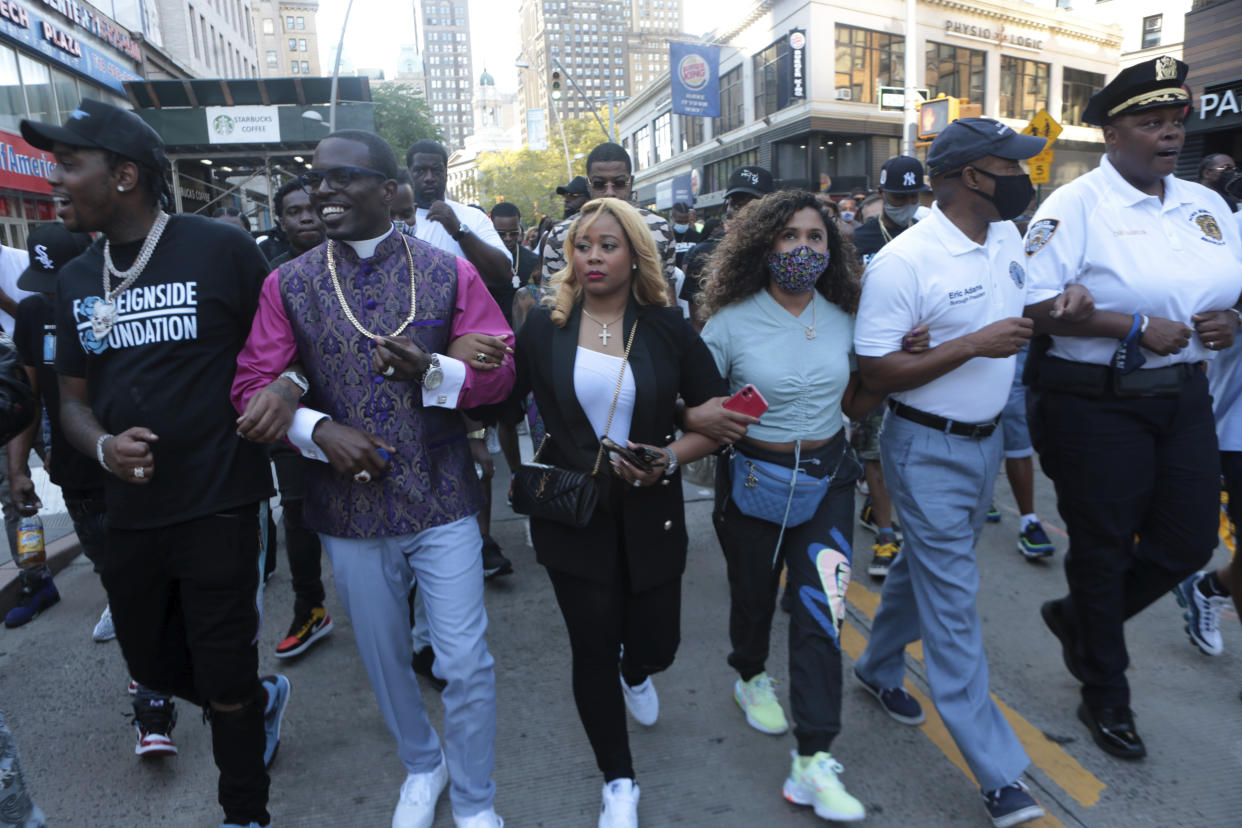 Adams links arms with others at a march organized by Bishop Lamor Whitehead in Brooklyn in 2020.