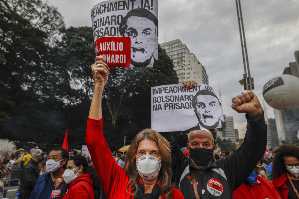 Demonstrators hold signs that read in Portuguese; "Impeachment now! Bolsonaro in prison" during a protest against Brazilian President Jair Bolsonaro and his handling of the COVID-19 pandemic, on Paulista Avenue in Sao Paulo, Brazil, Saturday, June 19, 2021. Brazil's COVID-19 death toll is expected to surpass the milestone of 500,000 deaths on Saturday night. (AP Photo/Marcelo Chello)