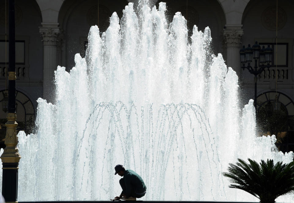 A worker cleans a fountain at the entrance of the Ritz Carlton hotel.