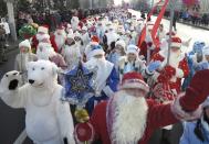 People dressed up as Father Frost, the equivalent of Santa Claus, and Snow Maiden, march as others perform in celebration of Christmas in central Minsk,December 25, 2013. REUTERS/Vasily Fedosenko (BELARUS - Tags: SOCIETY)